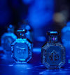 Octagonal perfume bottles with blue gemstone-style caps and decorative labels