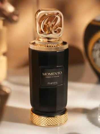 Black perfume extrait bottle with gold crown cap and gold band, front label detail