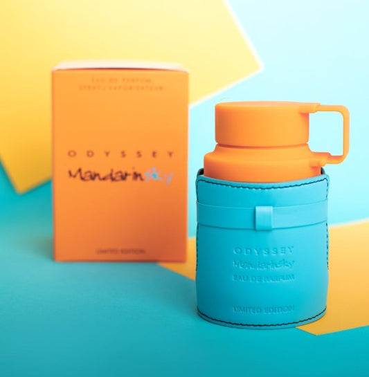 Eau de parfum bottle with orange cap, teal body and handle; includes matching box