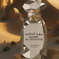 Faceted gold perfume bottle with cap and label reading MAHD AL DHAHAB