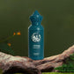 Teal glass fragrance bottle with raised emblem and faceted crown cap
