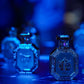 Octagonal perfume bottles with blue gemstone-style caps and decorative labels