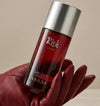 Assaf Risk Comète EDP bottle with silver cap, held in red glove