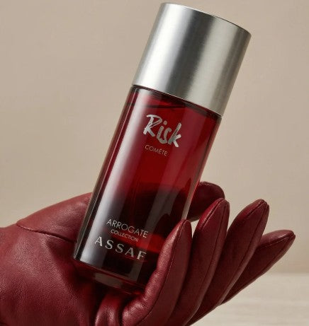 Assaf Risk Comète EDP bottle with silver cap, held in red glove