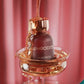Maroon fragrance bottle with gold cap, APHRODITE MYKONOS text and gold ring