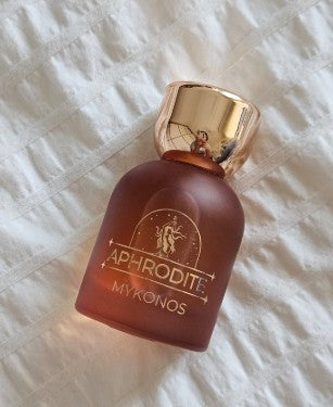 Maroon fragrance bottle with gold cap, label APHRODITE MYKONOS