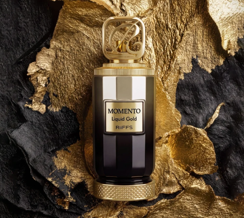 Perfume extrait de parfum bottle with gold cap on dark and gold rock texture