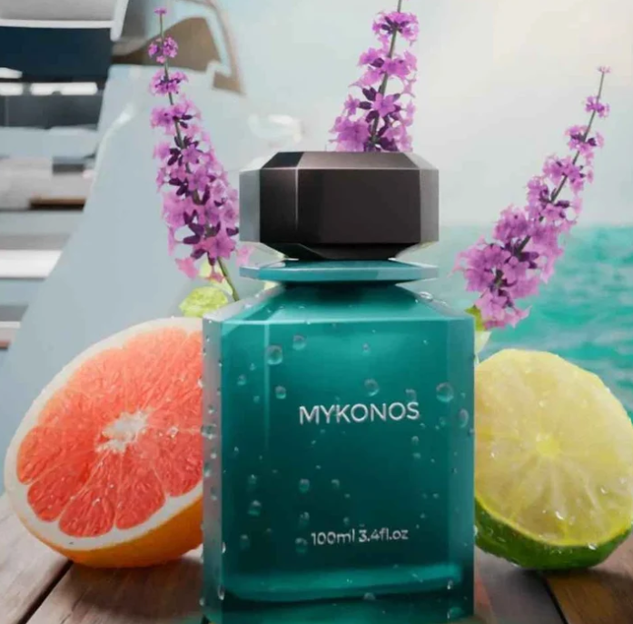 Teal perfume bottle with dark cap, MYKONOS label, citrus slices nearby