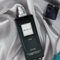 Black eau de parfum bottle with metallic cap, UNE label, 100ml