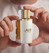 Perfume bottle held in hands, gold cap and white label with Dulook text